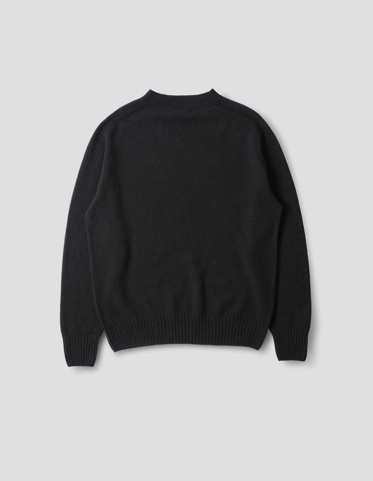 Black merino cashmere seamless jumper with ribbed crew neck, cuffs and hem. Back flat lay view.