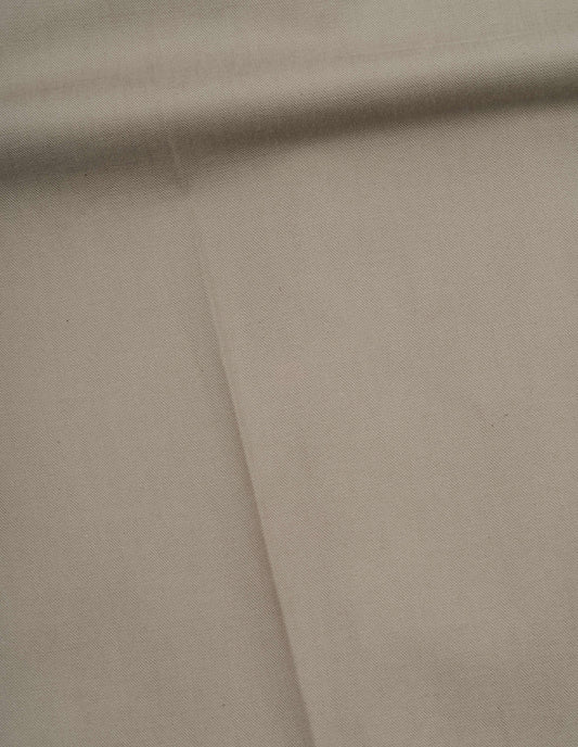 Beige dense cotton drill trousers fabric swatch.