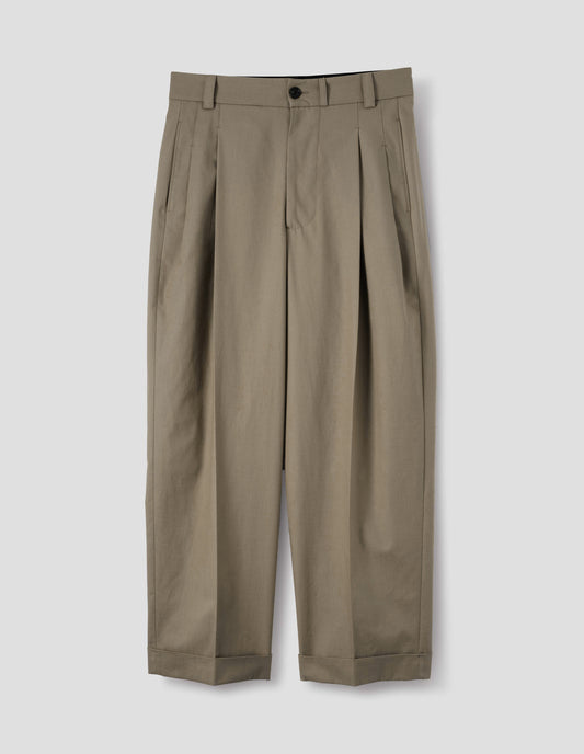 Beige cotton pleated trousers with horn button-through waistband with belt loops, concealed side pockets and cuffed hem. Front flat lay view.