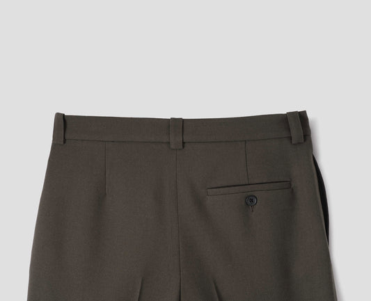 Brown wool trousers with side pockets and horn button-fastening welt back pocket. Back flat lay view.
