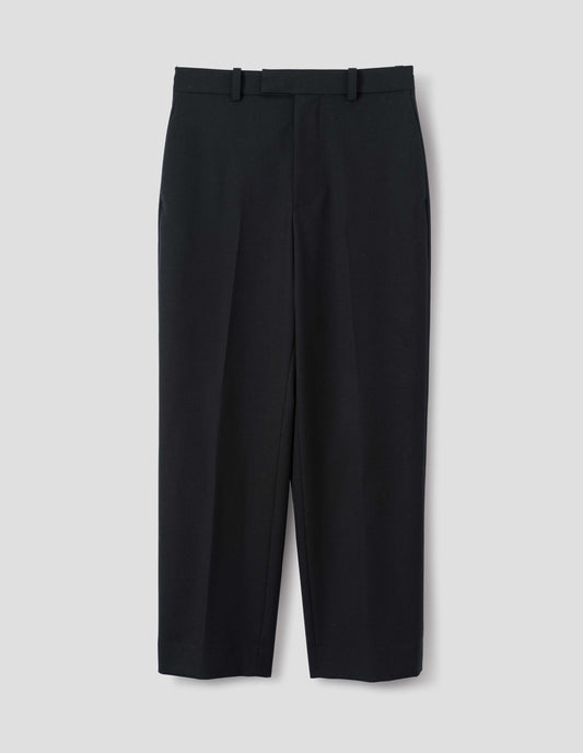 Black wool trousers with belt loops and waistband extension with hook and bar fastening. Front flat lay view.