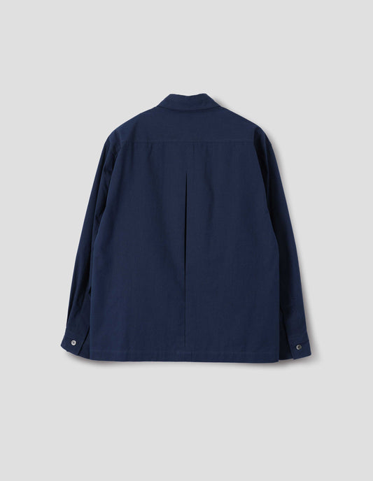 Dark blue cotton shirt with mother of pearl buttons on cuffs, deep inverted pleat at back yoke and vent split hem. Back flat lay view.