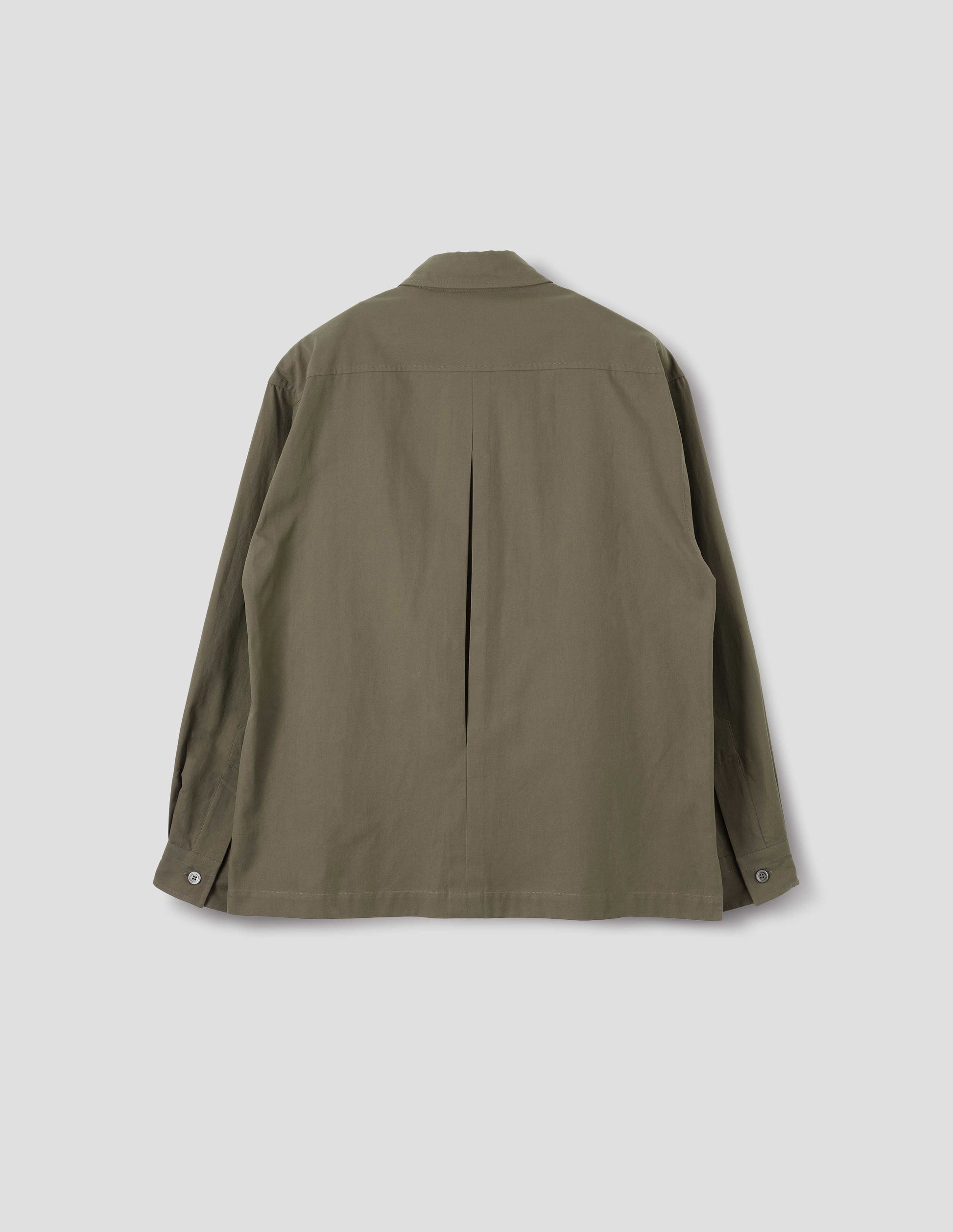 Green cotton shirt with mother of pearl buttons on cuffs, deep inverted pleat at back yoke and vent split hem. Back flat lay view.