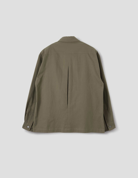 Green cotton shirt with mother of pearl buttons on cuffs, deep inverted pleat at back yoke and vent split hem. Back flat lay view.