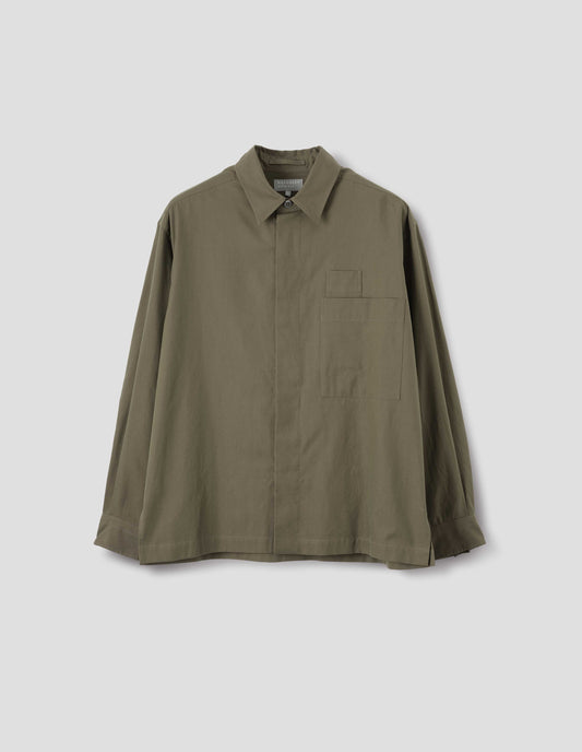 Green cotton shirt with concealed placket and mother of pearl button on collar, large patch chest pocket with internal pen pocket and vent split hem. Front flat lay view.