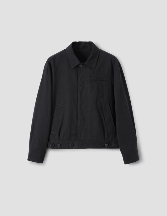 Black jacket with slant and chest pockets and horn button closure and cuffs, front flat lay view.