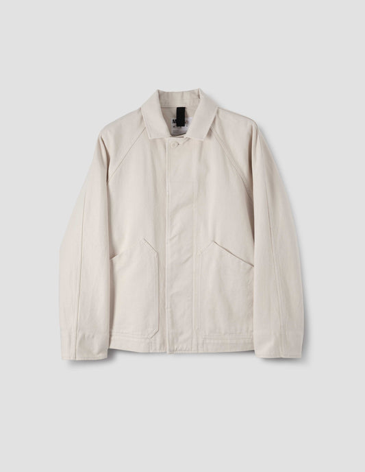 Off white raglan sleeve jacket with slant patch pockets and corozo button fastening, front flat lay view.