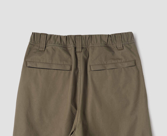 Green trousers with elasticated waistband, zip welt back pockets and belt loops. Back flat lay view.