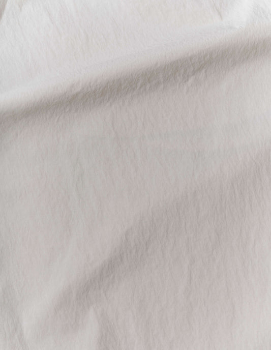 Light grey trousers, lightweight nylon taslan fabric swatch.