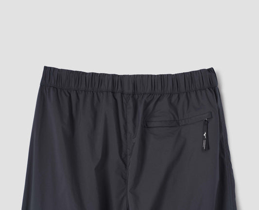 Dark navy trousers with elasticated waist and zip back pocket. Back flat lay view.