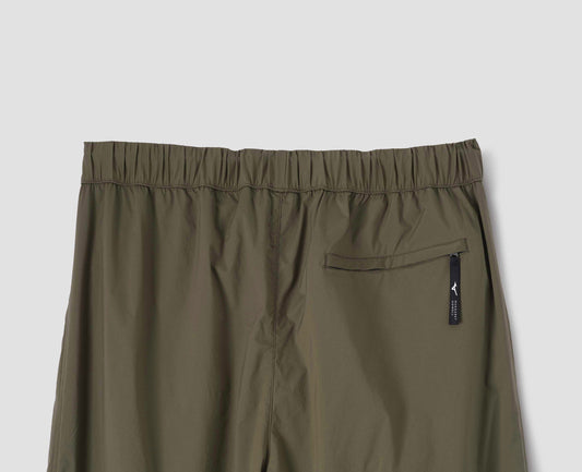 Green/brown trousers with elasticated waist and zip back pocket. Back flat lay view.