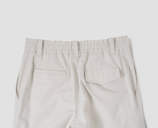 Off white trousers, with half-elasticated waistband, belt loops and concealed button fastening flap back pocket. Back flat lay view.