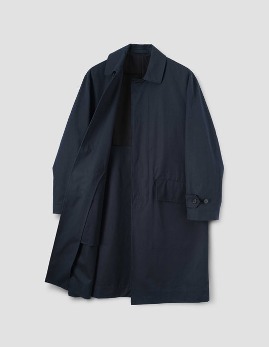 Navy blue longline mac with horn button closure and cuffs and slanted envelope flap pockets, front flat lay  open view.