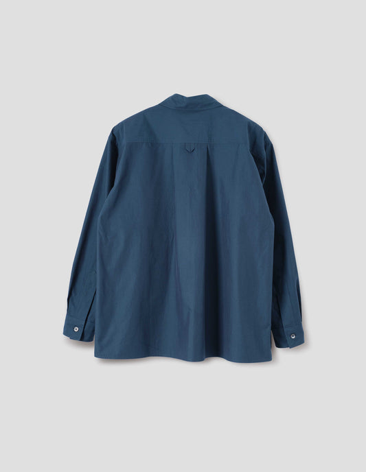 Blue shirt with deep side split vents, elongated back, box pleat and hanger loop detail on back yoke, mother of pearl buttons on cuffs. Back flat lay view.