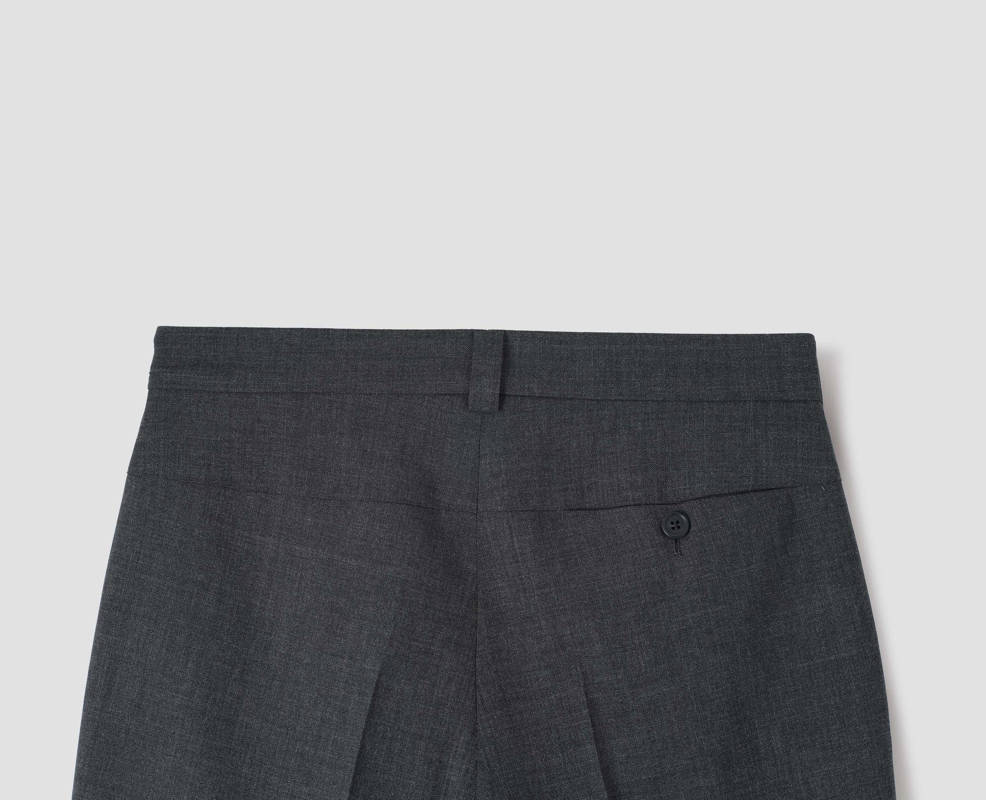 Grey crisp wool trousers, with horn button fastening concealed pocket and belt loop. Back flat lay view. 