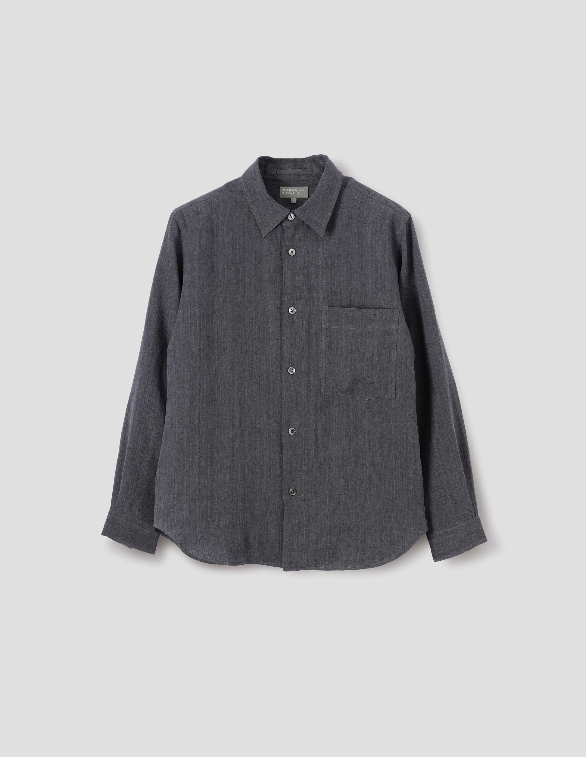 Dark grey cotton long sleeve shirt, with mother of pearl buttons, curved hem and chest patch pocket. Front flat lay view.