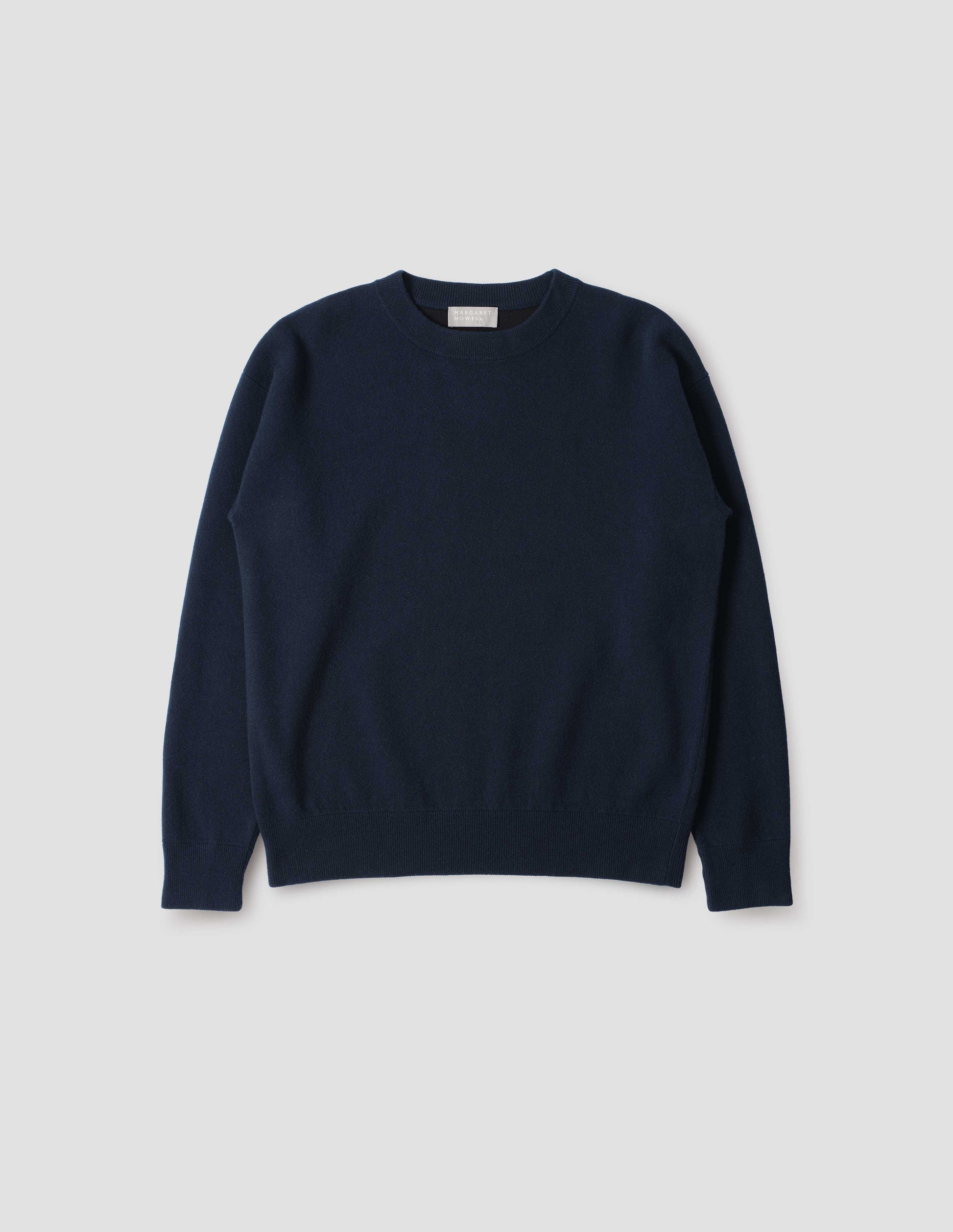 Dark blue knitted sweatshirt with rib collar, cuffs and hem. Front flat lay view.