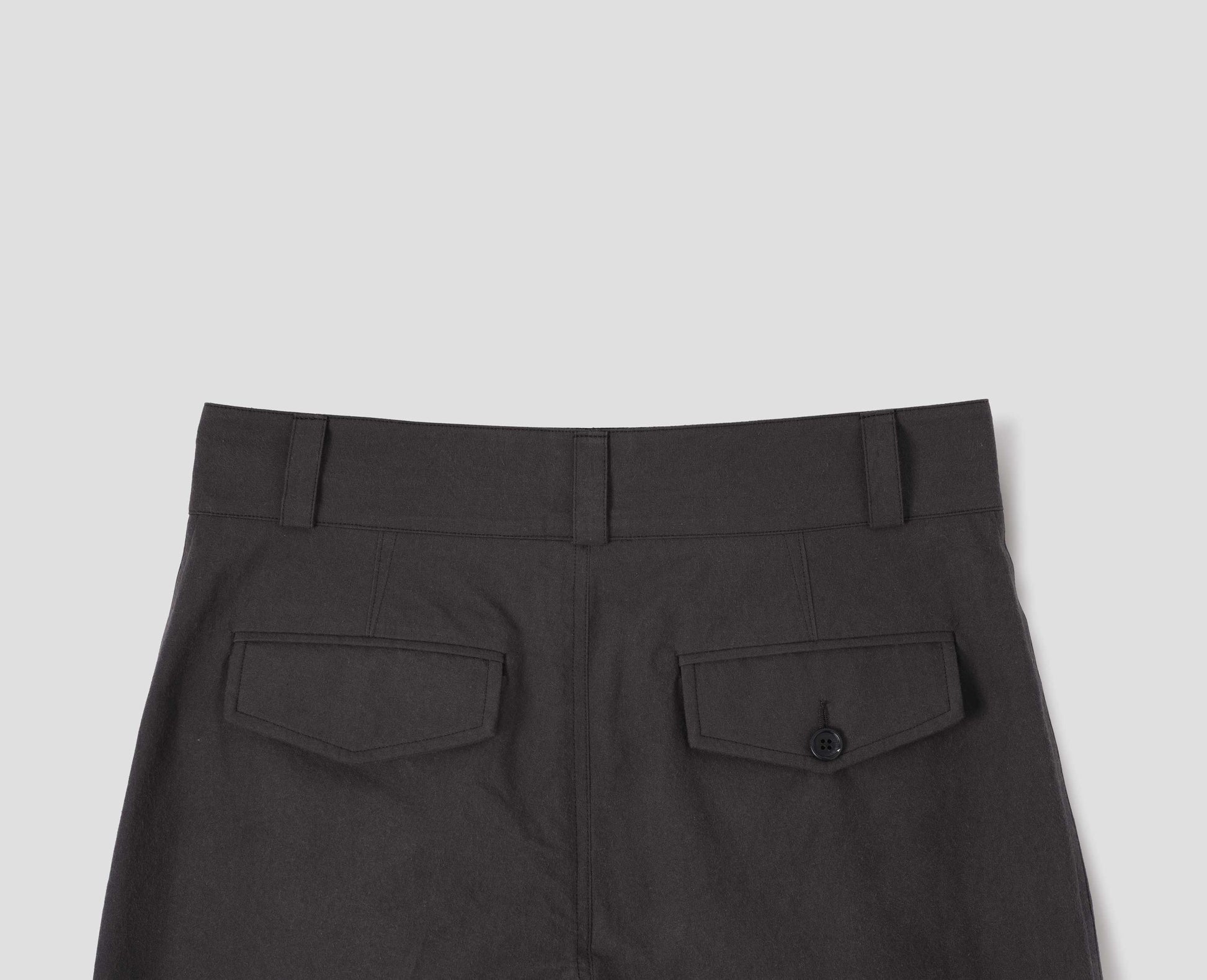 Dark brown cotton trousers with belt loops and concealed and button through jet back pockets. Back flat lay view.