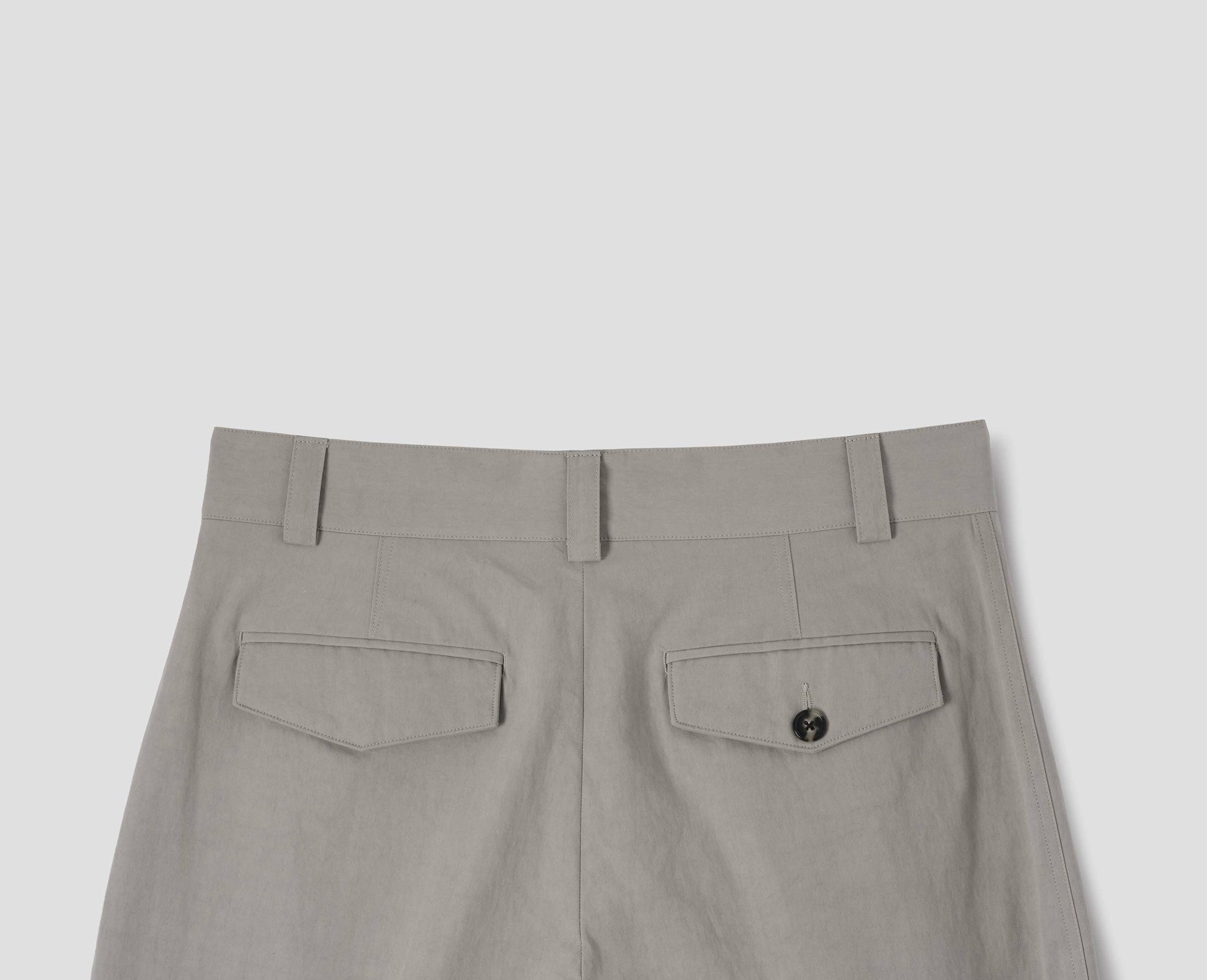 Light grey cotton trousers, with belt loops and concealed flap and button-through jet back pockets. Back flat lay view.