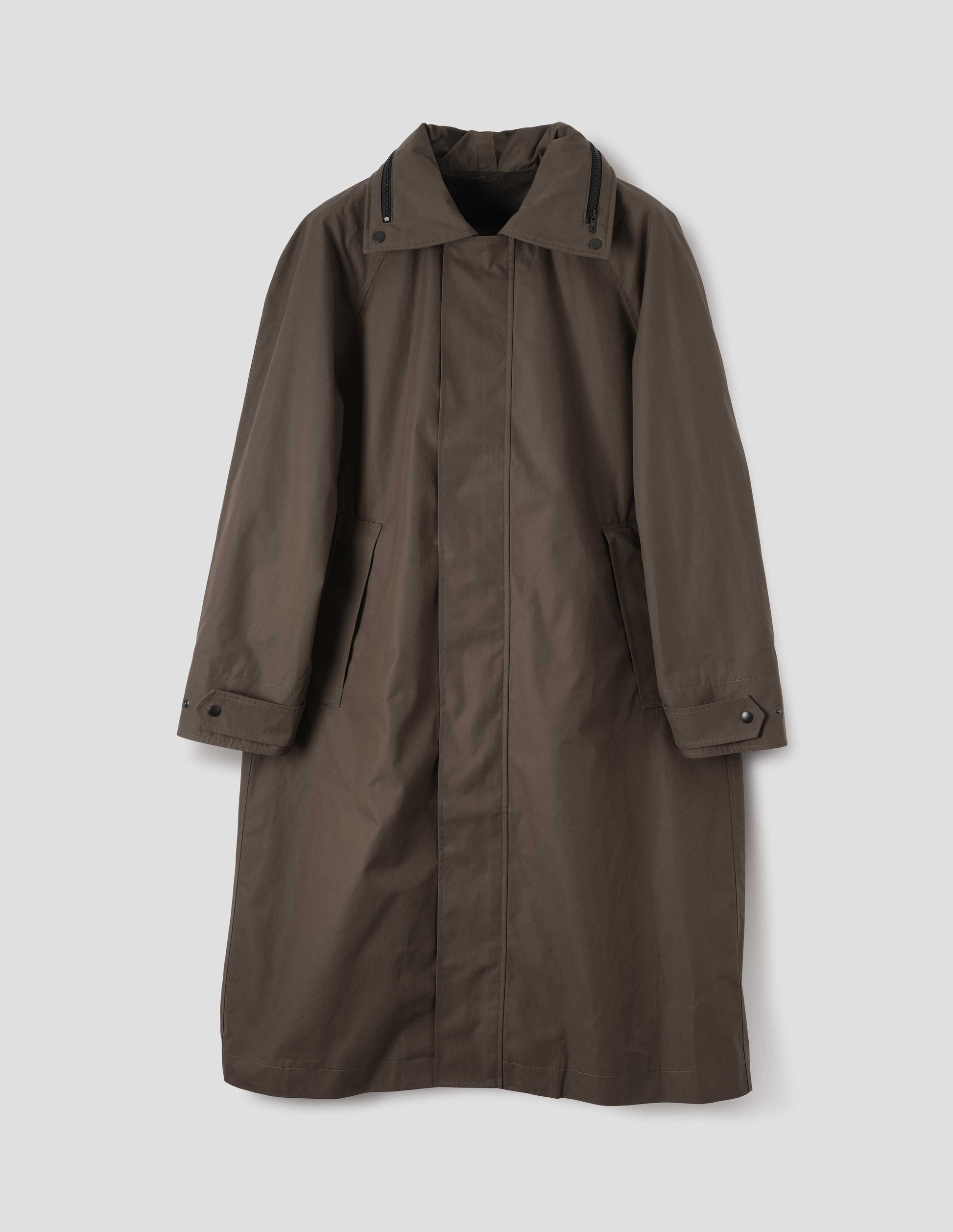 Greenish brown ventile cotton poplin longline mac with raised placket, slant pockets, adjustable popper cuffs and contrast black zip detailing on collar. Front flat lay view.