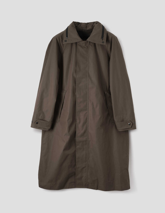 Greenish brown ventile cotton poplin longline mac with raised placket, slant pockets, adjustable popper cuffs and contrast black zip detailing on collar. Front flat lay view.