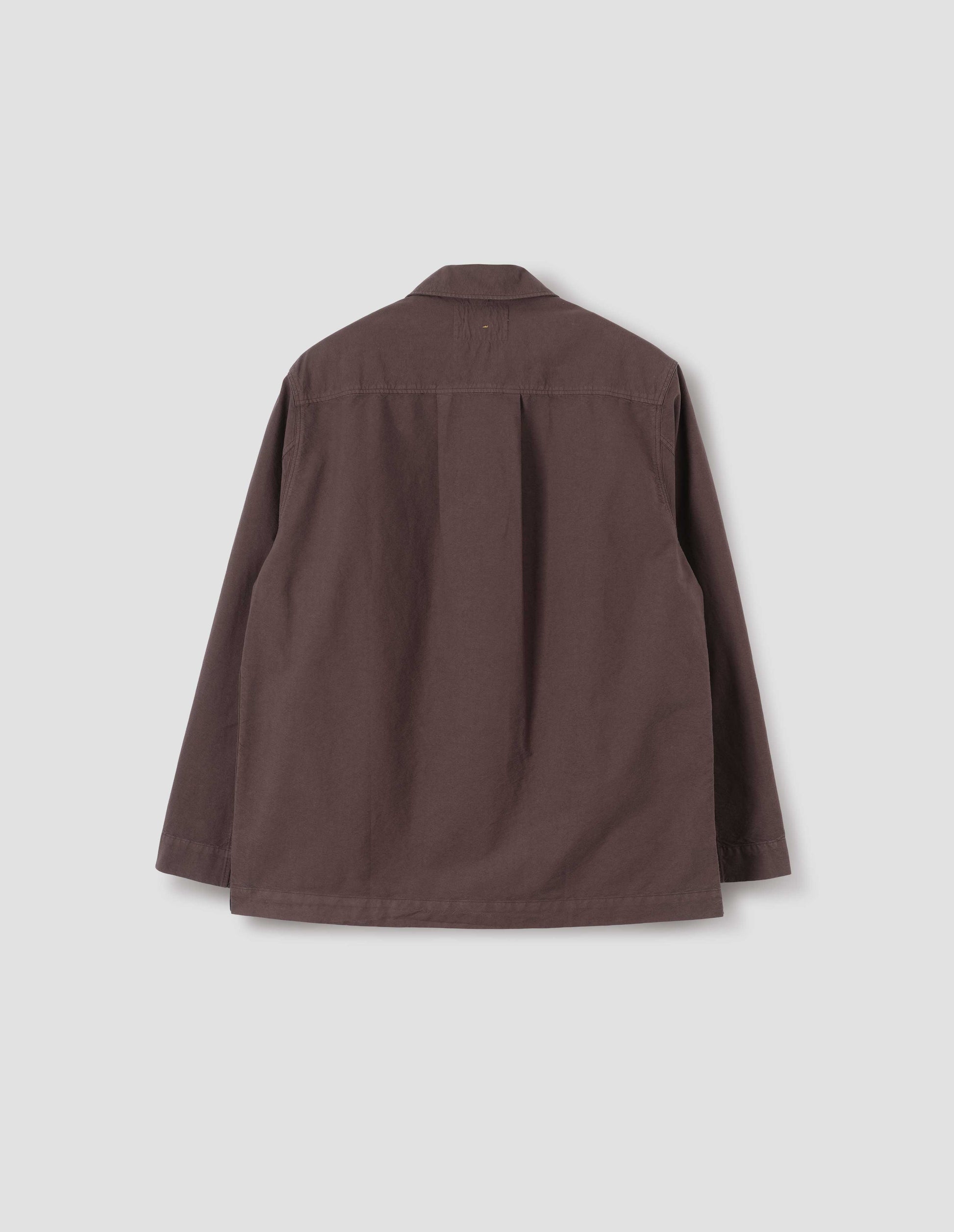 Brown shirt with straight cuffs, side split hem and box pleat on back yoke. Back flat lay view.
