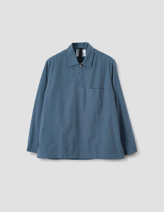 Blue shirt with wide stitch-through placket with half zip, large patch chest pocket, straight cuffs and and side split hem. Front flat lay view.
