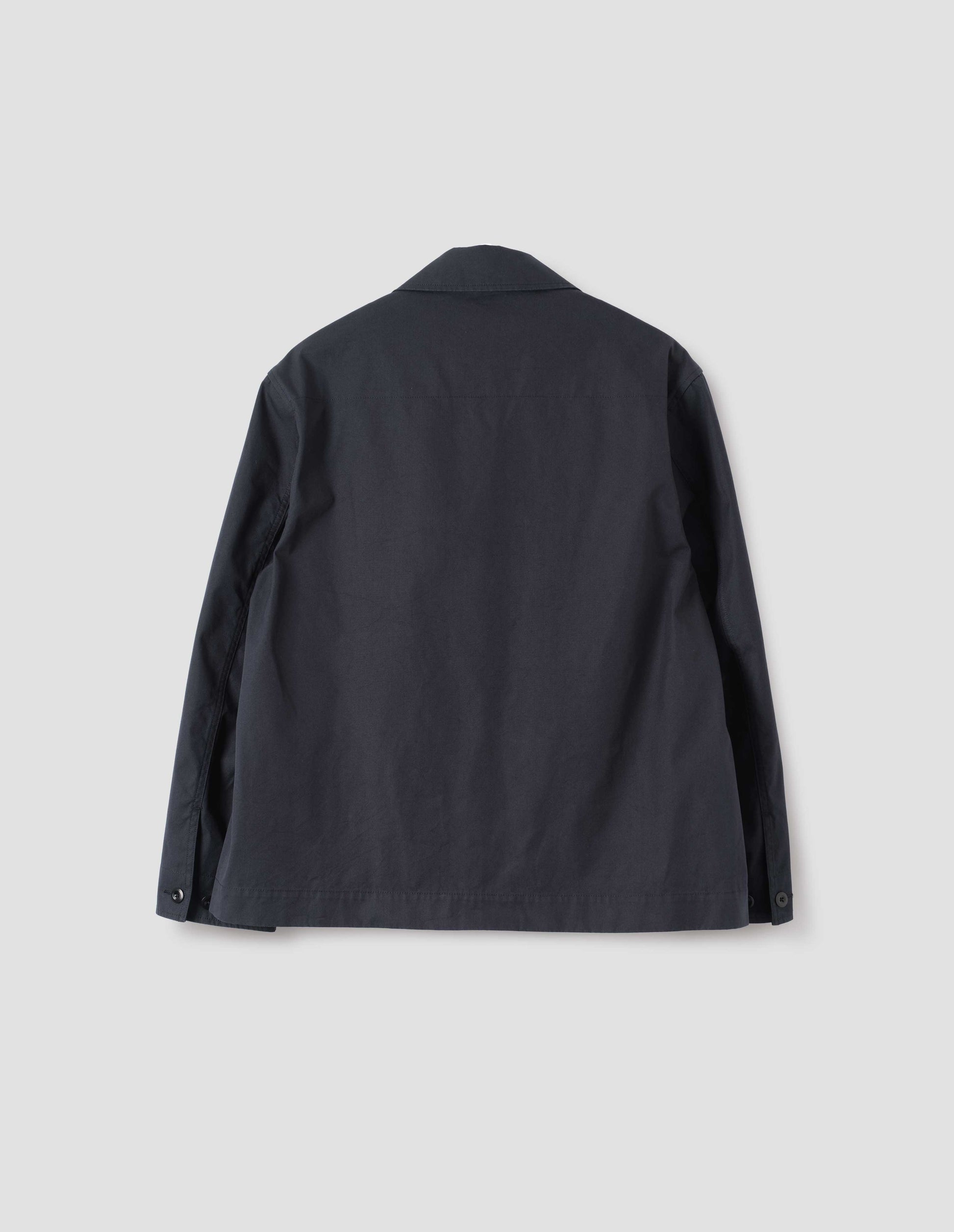 Dark navy blue cotton blazer, with horn button closure cuffs. Back flat lay view.