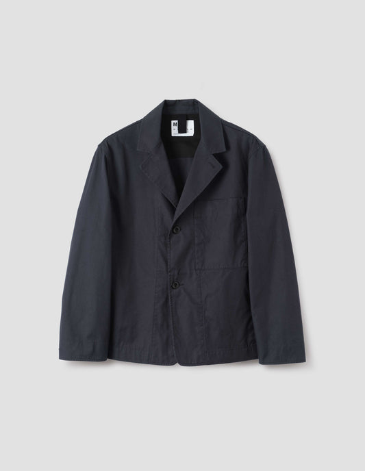 Dark navy blue cotton blazer, with horn button fastening lapel, large patch chest pocket and side pockets. Front flat lay view.