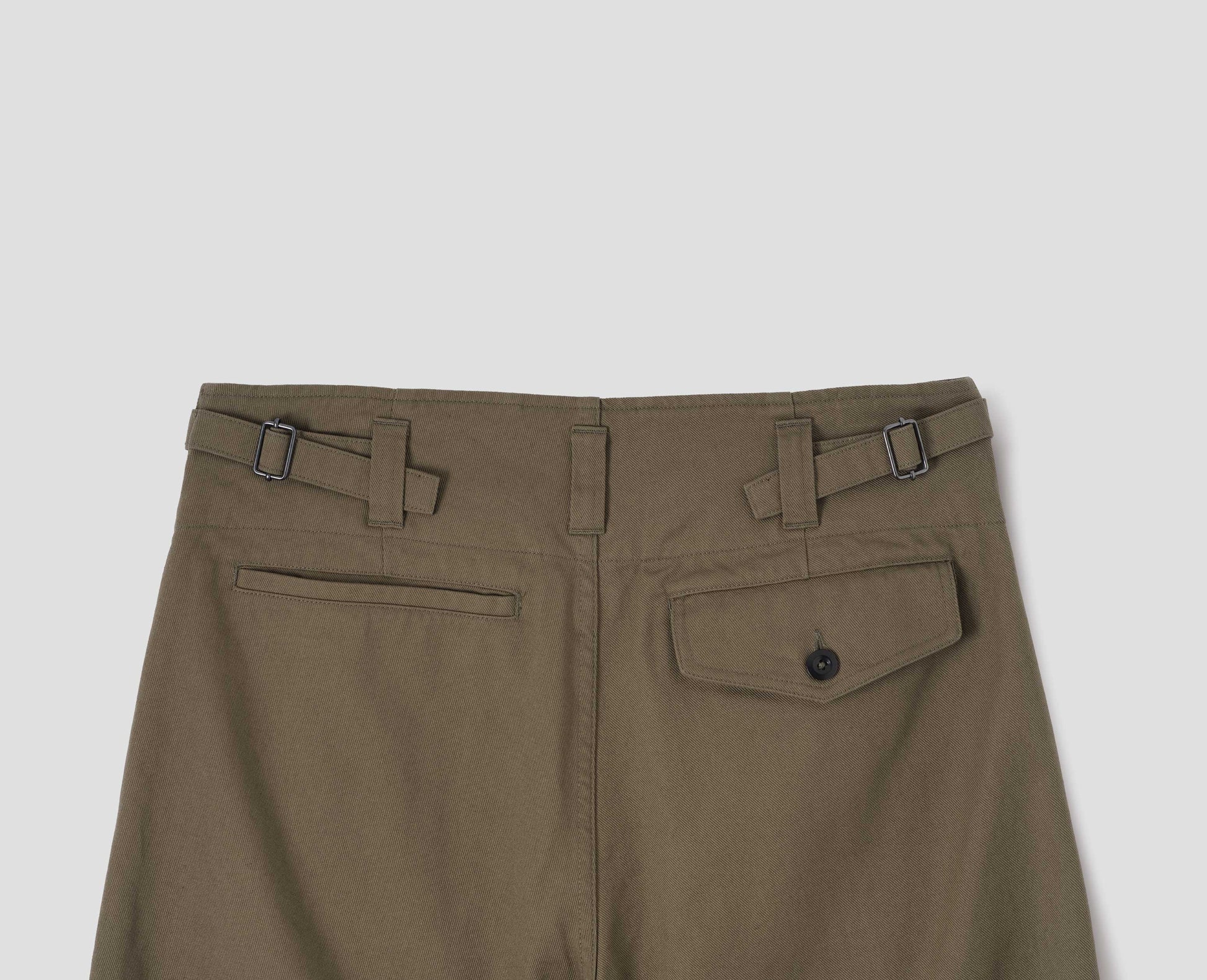 Green cotton drill trousers with belt loops, side adjustors, welt back and flap back pockets. Back flat lay view.