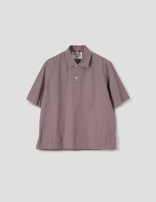 Pink cotton short sleeved polo shirt with side split hem and corozo brace button half placket. Front flat lay view.