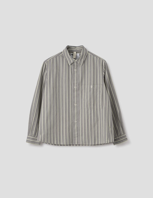 Grey, white and yellow striped long sleeve cotton shirt. With dropped shoulder, raised placket, corozo brace button closure and button through chest patch pocket. Front flat lay view.