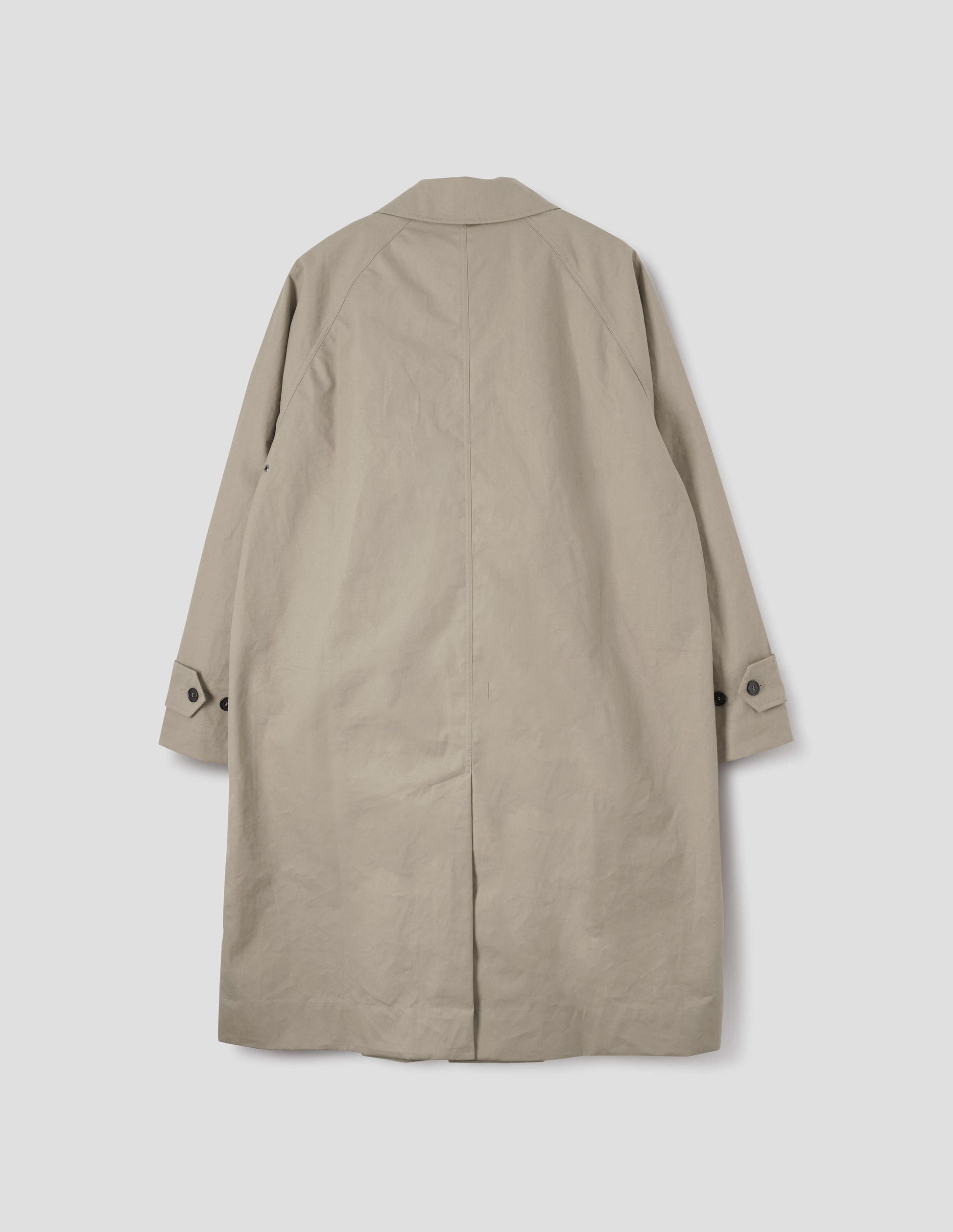 Beige long sleeve cotton mac, with raglan sleeve, button tab adjustable cuffs and rear vent. Back flat lay view.