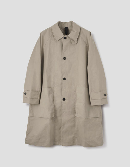 Beige long sleeve cotton mac, with storm tab fastening neck, raglan sleeve, button tab adjustable cuffs and large patch bellow pockets. Front flat lay view.