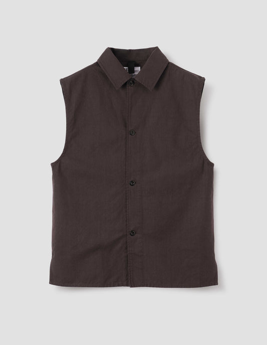 Dark brown cotton drill sleeveless overshirt with corozo button fastening, hanger loop on inside of collar and vent split hem. Front flat lay view.