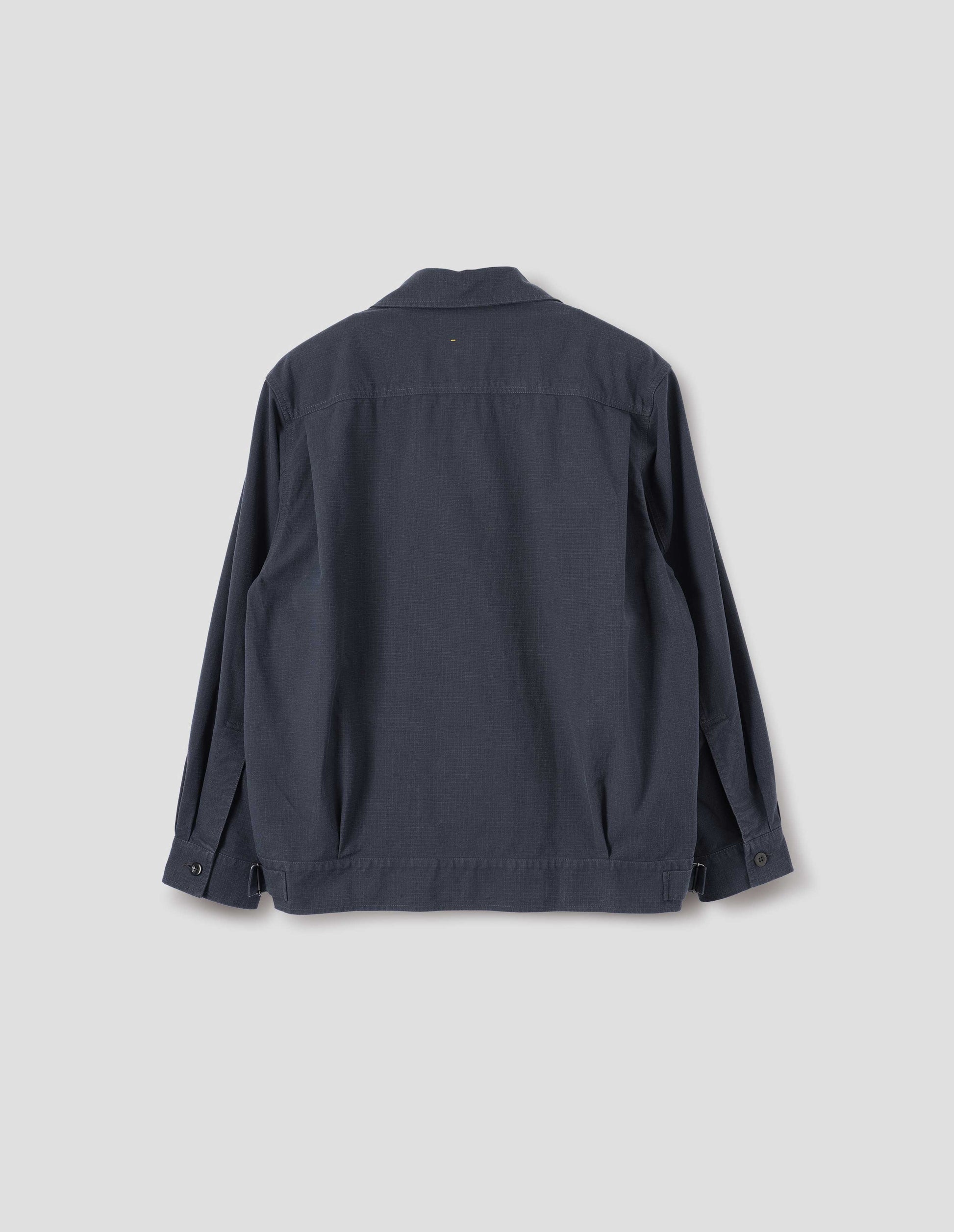 Dark blue jacket with shirt cuffs, small pleats at hem and side adjustors on waistband. Back flat lay view.