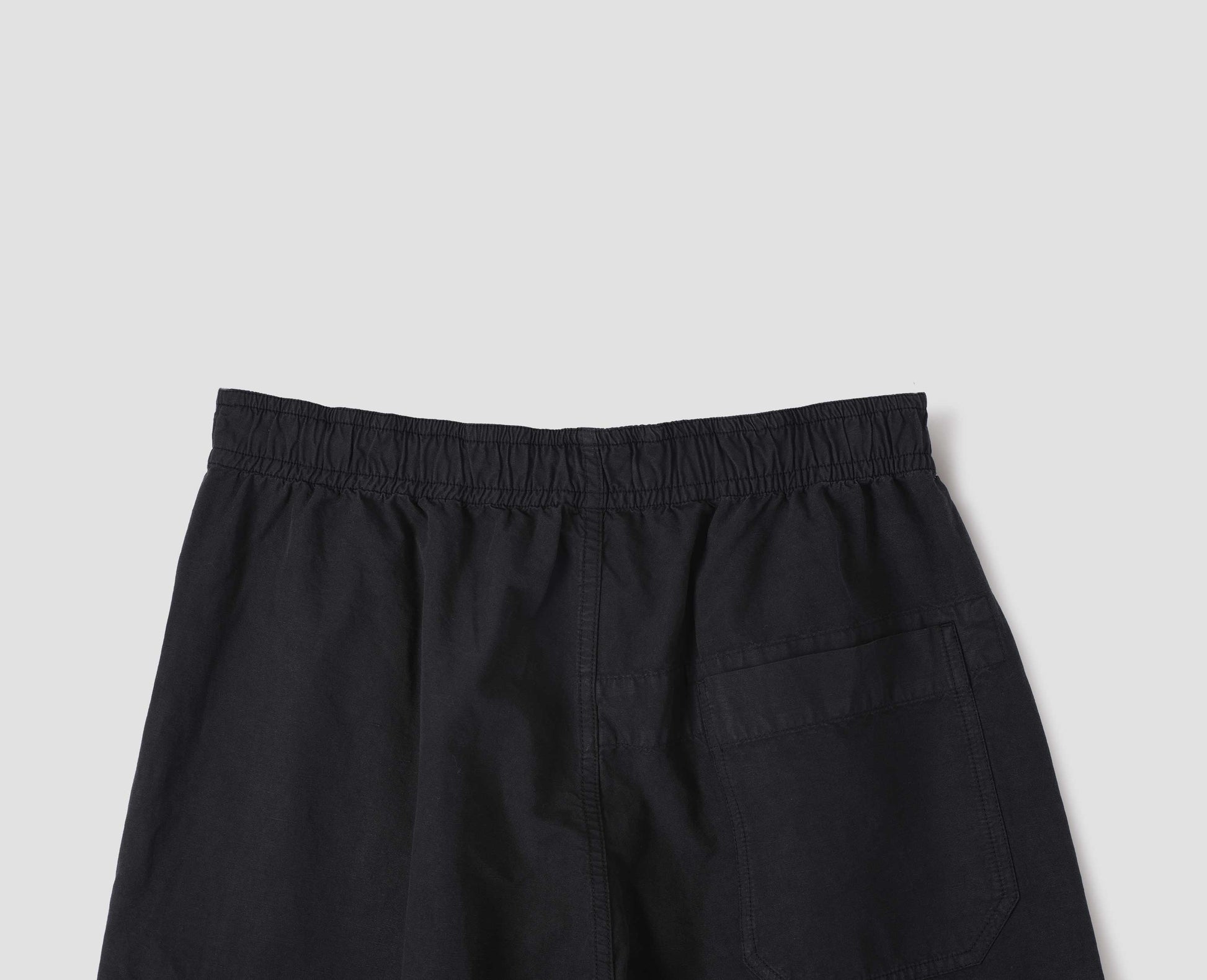 Black joggers with elasticated waist and  patch back pocket. Back flat lay view.