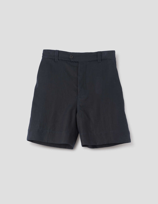 Dark blue shorts with half-elasticated waistband with belt loops, horn button fly with button tab fastening and slant side pockets. Front flat lay view.