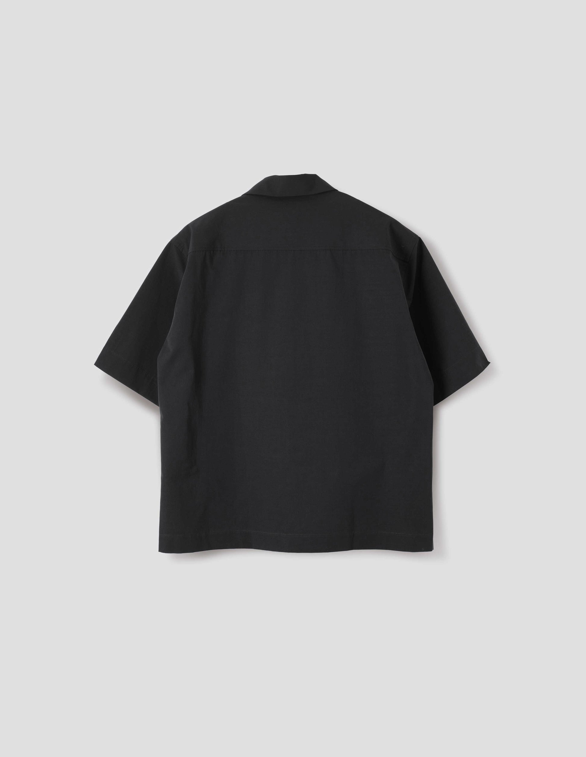 Black short-sleeved shirt with side split hem. Back flat lay view. 