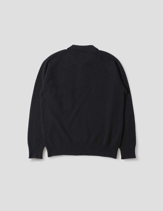 Black merino cashmere polo shirt with dropped sleeve and rib collar, cuffs and hem. Back flat lay view.
