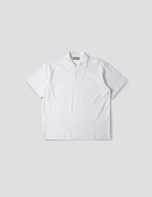 White cotton short sleeve polo shirt with wide placket and horn buttons. Front flat lay view. 