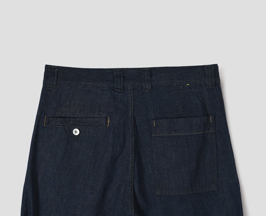 Dark blue denim twill trousers with high waist, belt loops, metal button-through welt and patch back pocket. Back flat lay view. 