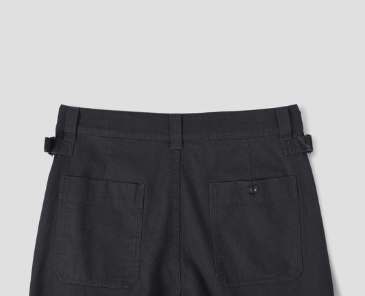 Dark blue trousers with belt loops and side cinches, corozo button-through patch back pockets. Back flat lay view.