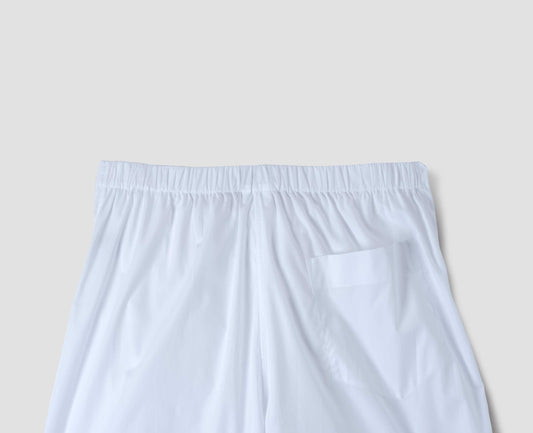 White lightweight cotton cropped PJ pants with gathered back and patch back pocket. Back flat lay view.