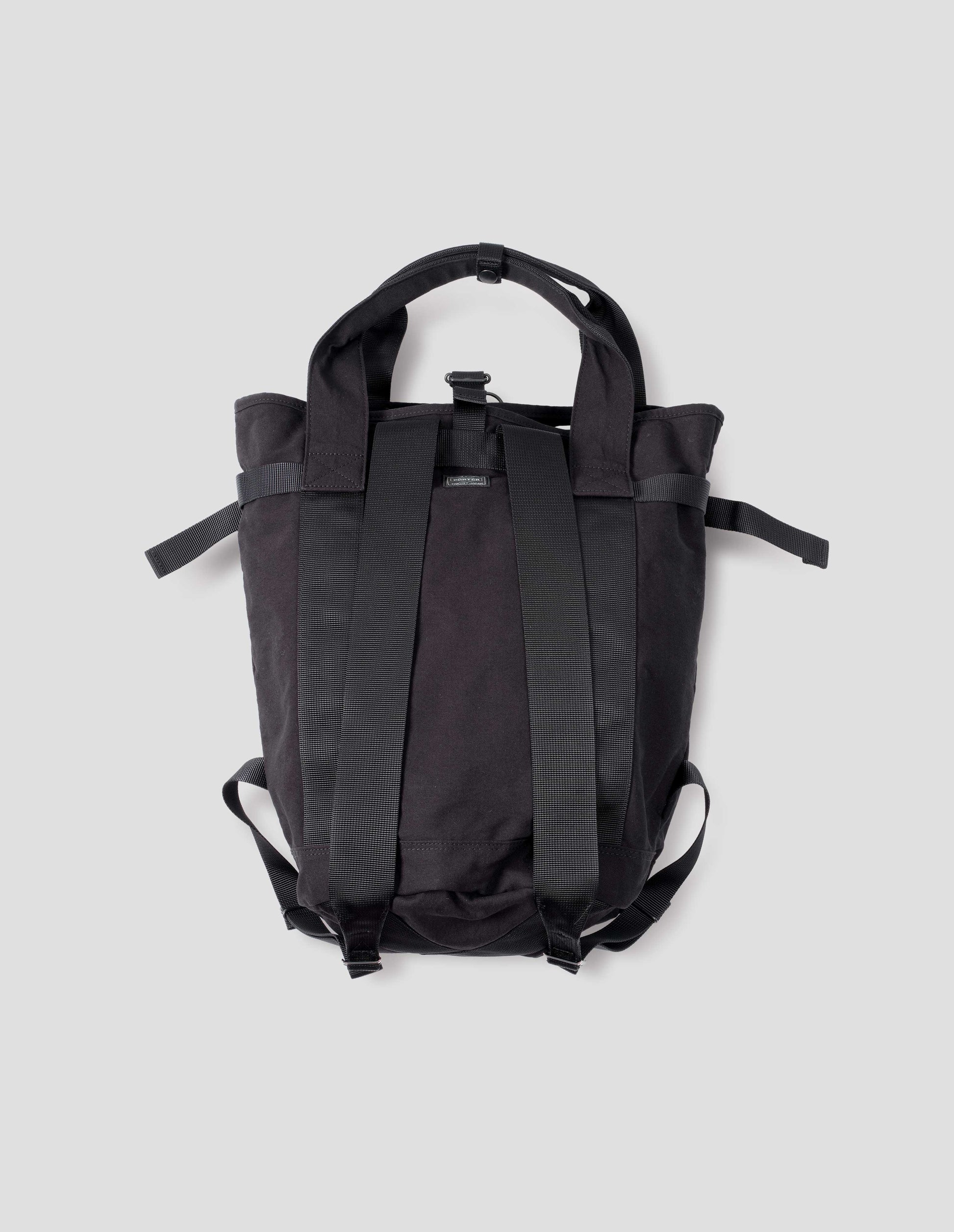 Black backpack with contrast webbing on handles and shoulder straps, side strap adjustors. Back flat lay view above.