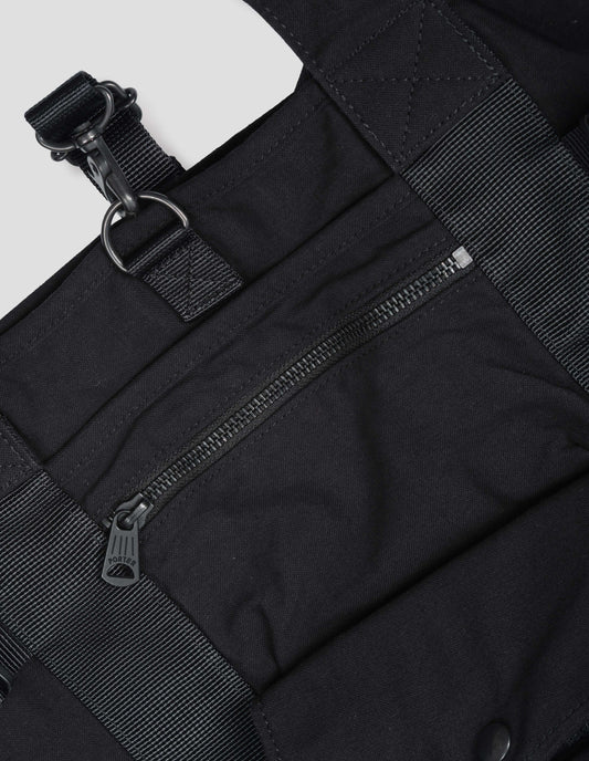 Black backpack with contrast webbing, zip pocket and press stud pocket. Detail flat lay view.