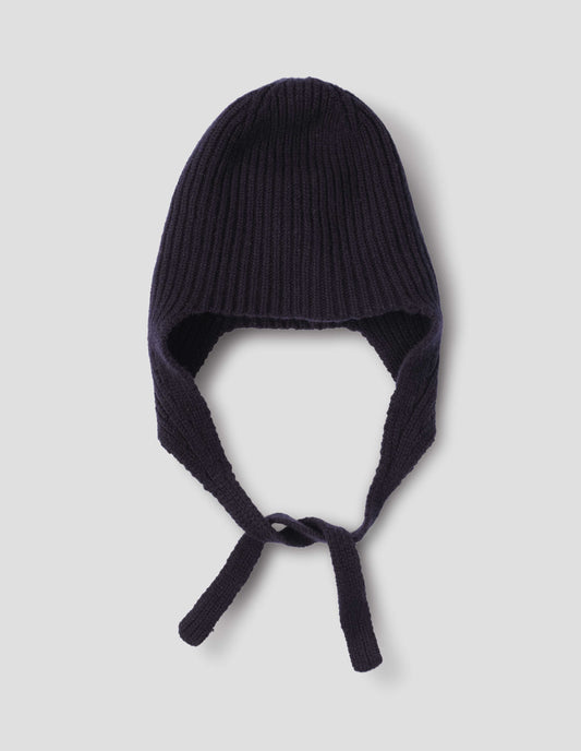 A navy blue rib knitted hat with ear flaps and tie detail, front flat lay view.