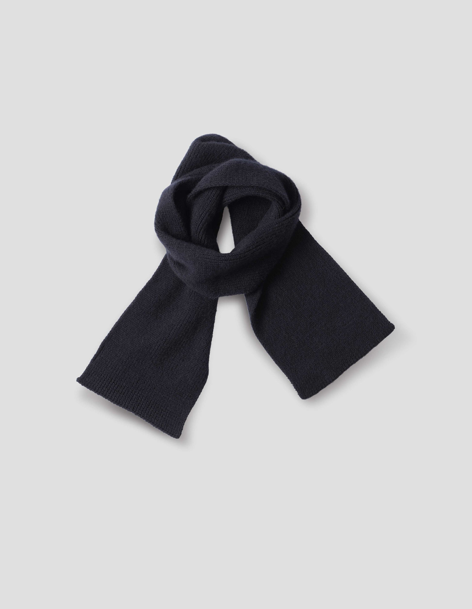 Dark navy blue knitted wool scarf, front flat lay view.