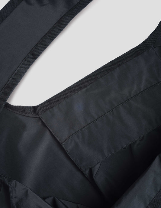 Black proofed cotton cotton bag with matte finish, with herringbone tape faced handles. Fabric swatch.