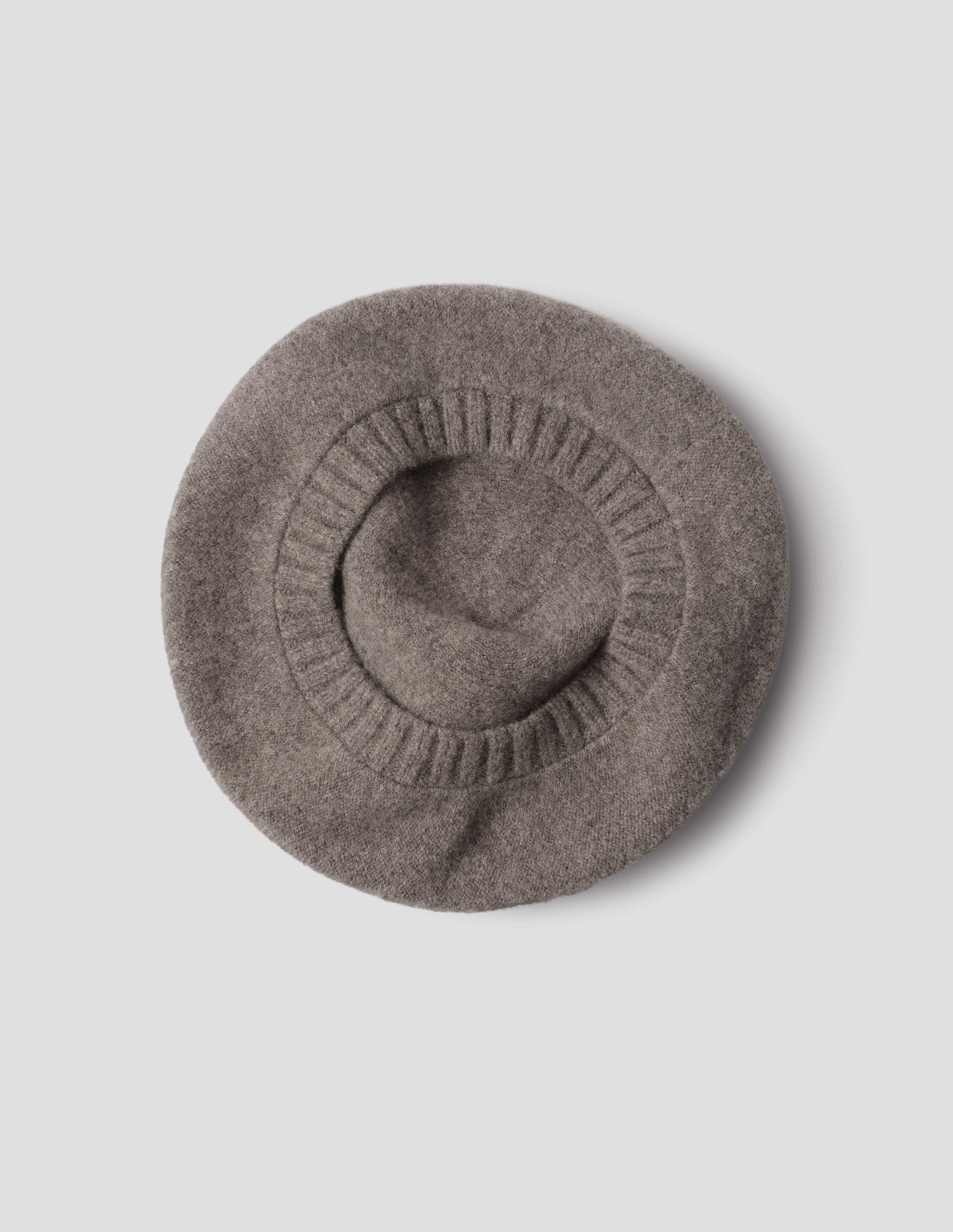 Greyish beige wool tam o shanter hat with contrast ribbing. Back flat lay view.